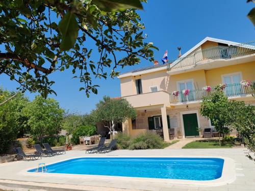 a villa with a swimming pool in front of a house at Šimun&Jakov in Drinovci