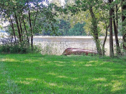 a boat sitting in the grass near a body of water at 6 person holiday home in HÄSTVEDA-By Traum in Hästveda