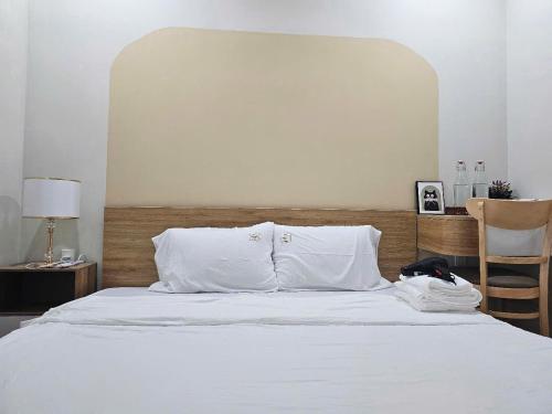 a bed with white sheets and pillows in a bedroom at Giao Homestay in Thôn Văn Dương