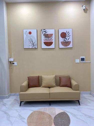a living room with a couch and four pictures on the wall at Giao Homestay in Thôn Văn Dương