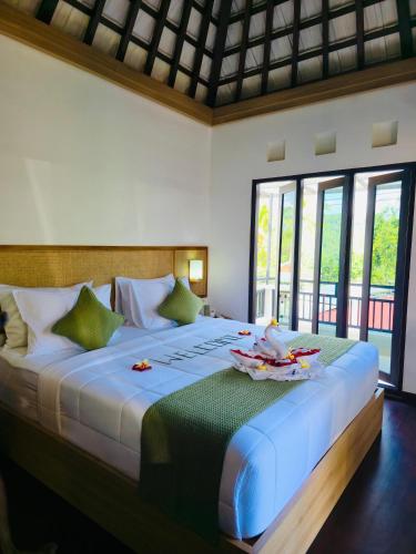 a bedroom with a large bed with towels on it at PARAWIYA Villa in Munduk