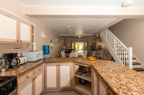 a kitchen with a counter top and a staircase at Bayview Town House 10- Central Stay with Ocean Views in Gros Islet