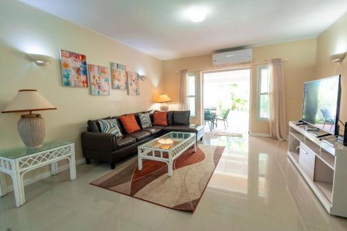 a living room with a couch and a tv at Bayview Town House 10- Central Stay with Ocean Views in Gros Islet