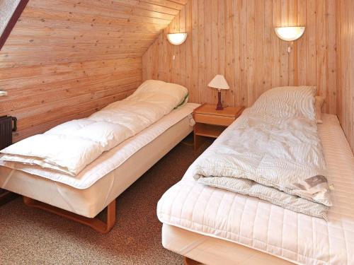 two beds in a room with wooden walls at Tranquil Haven in Ansager - By Traum Ferienwohnungen in Ansager
