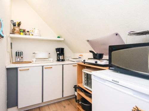a kitchen with white cabinets and a flat screen tv at Tranquil Haven in Ansager - By Traum Ferienwohnungen in Ansager
