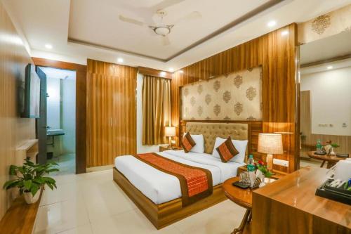 a bedroom with a bed and a desk in a room at Almati Hotel - Near Delhi Airport With - free Airport Pickup in New Delhi
