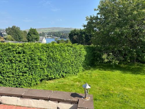 a parking meter in the grass next to a hedge at Feochan Portree in Portree