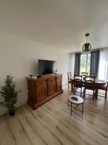 a living room with a flat screen tv and a table at Champions Deluxe in Sarcelles
