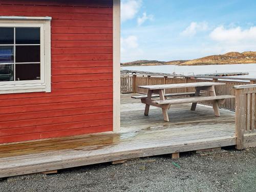 a wooden deck with a picnic table next to a building at 4 star holiday home in Oksvoll in Oksvoll