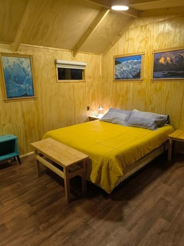 a bedroom with a large yellow bed in a room at Isla yu backpacker in Puerto Natales