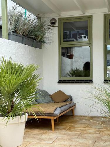 a bench sitting in a patio with potted plants at Hanzestekje Harderwijk in Harderwijk