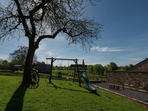 a playground with a slide next to a tree at Bertrix Mill with Sauna in Sart
