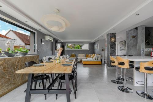 a dining room and kitchen with a table and chairs at Gîtes Spa Strasbourg - La Villa 14 in Furdenheim