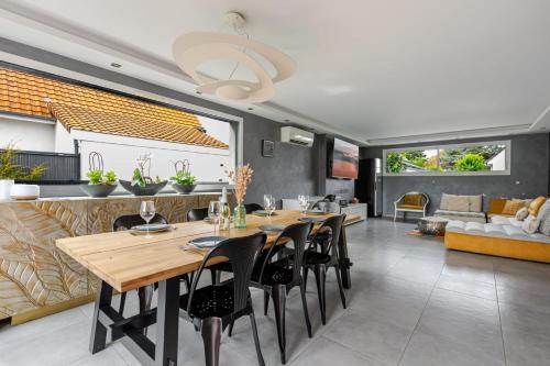 a dining room and living room with a table and chairs at Gîtes Spa Strasbourg - La Villa 14 in Furdenheim