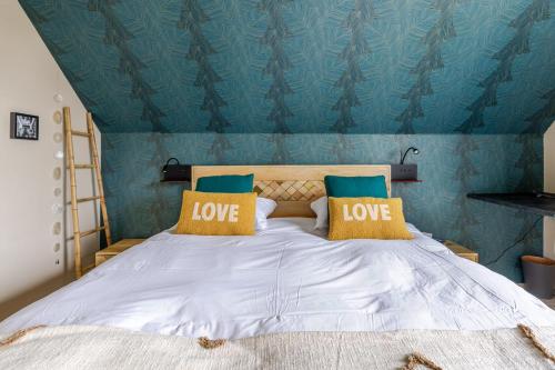 a bedroom with a bed with love pillows on it at Gîtes Spa Strasbourg - La Villa 14 in Furdenheim