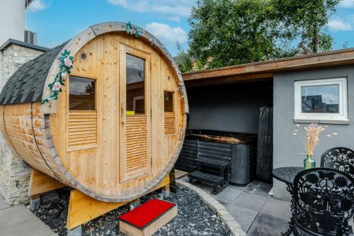 a large wooden barrel sitting next to a house at Gîtes Spa Strasbourg - La Villa 14 in Furdenheim
