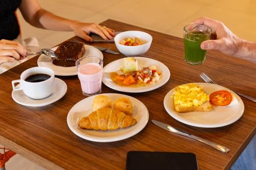 a table topped with plates of breakfast foods and drinks at Ibis Votuporanga in Votuporanga