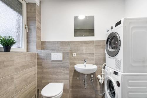 a bathroom with a washing machine and a sink at Work & Stay Apartment mit Balkon in Bergkamen in Bergkamen