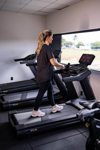 a woman running on a treadmill in a gym at Ibis Votuporanga in Votuporanga