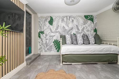 a bedroom with a bed with green and white wallpaper at 236 On Cape in Gqeberha