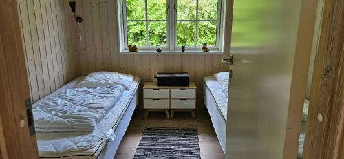 mały pokój z dwoma łóżkami i oknem w obiekcie Cozy Cottage Just 300 M From Høve Beach w mieście Asnæs
