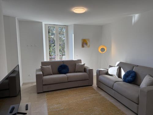 a living room with two couches and a flat screen tv at Schloss Locarno - Self Check-In in Locarno