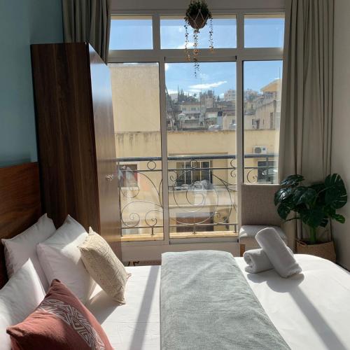 a bedroom with a bed and a large window at Mar Mikhael Studios in Beirut