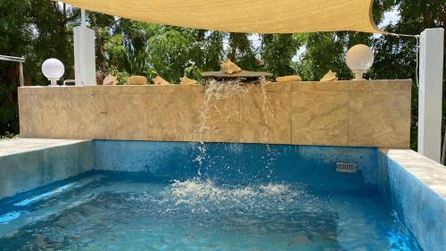 a swimming pool with a fountain in a backyard at Corales Punta Rusia in Punta Rucia