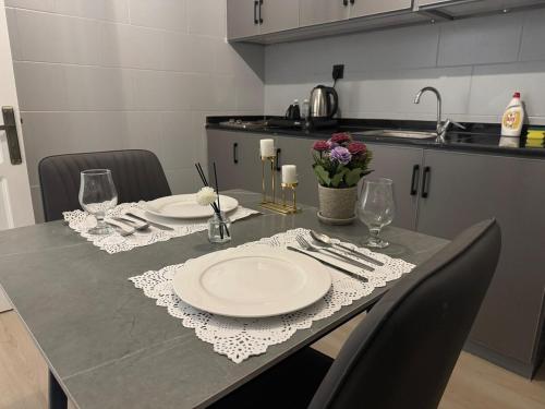 a table with plates and napkins on it in a kitchen at شقه بتصميم فاخر وراقي-حي السلامة in Jeddah