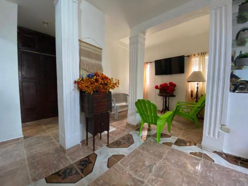 sala de estar con sillas verdes y mesa en Recidencial sharael house, en San Isidro