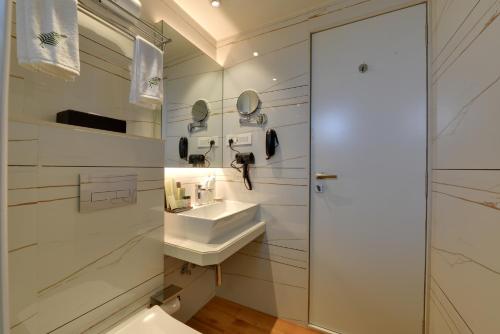 a white bathroom with a sink and a toilet at The Fern Residency Mira Road,Mumbai in Mumbai