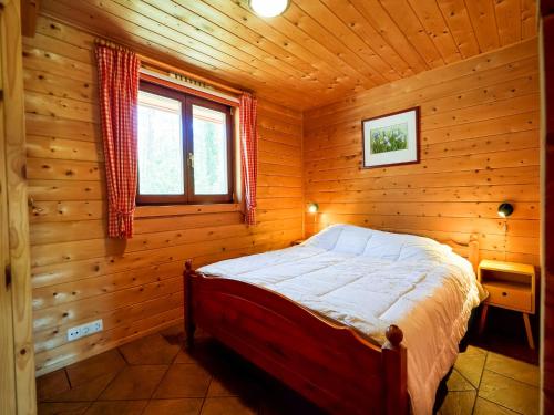 a bedroom with a bed in a wooden cabin at Bungalow in Holten near Forest Trails in Holten