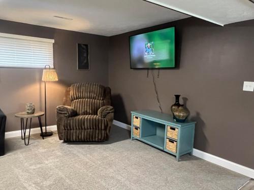 sala de estar con silla y TV en la pared en Curtis Creek Lakehouse, en Junction City