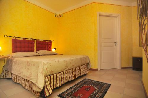 a bedroom with a bed and a yellow wall at Monticello Village in Monticello d'Alba