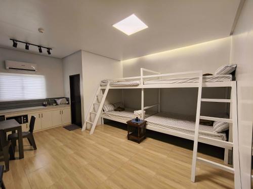 a room with two bunk beds and a desk at Amado Transient Inn in Prado