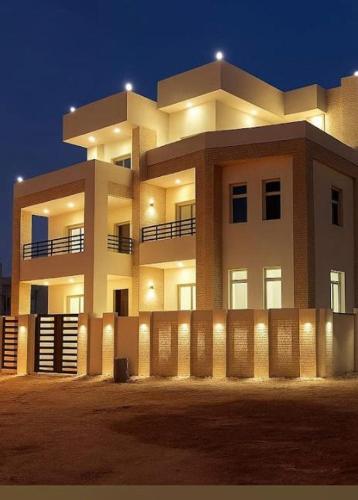 a large white building with a fence in front of it at شقق وفلل بيوت السلام in Salalah