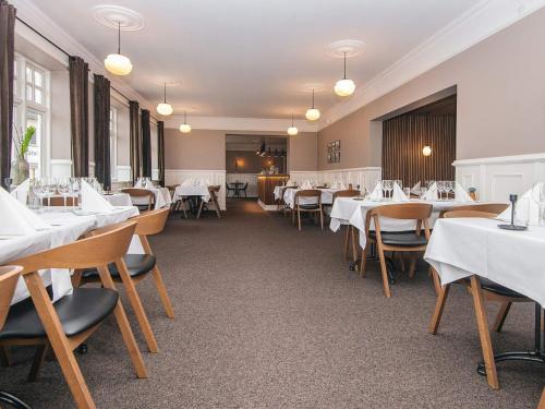 a dining room with white tables and chairs at 4 person holiday park home in Give in Give