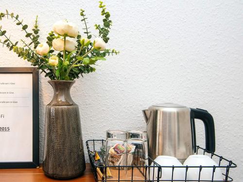 a vase with flowers and a tea kettle on a table at 4 person holiday park home in Give in Give