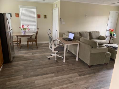 a living room with a couch and a table with a laptop at Day Street - Walk to Harpers Ferry NP in Bolivar