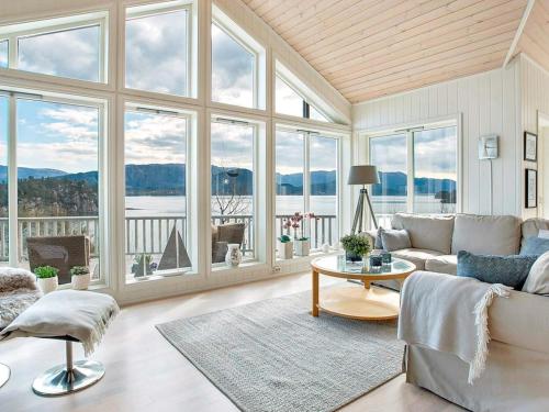 a living room with a couch and a table and windows at 4 star holiday home in Valevåg in Valevåg