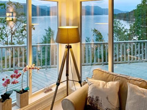 a living room with a lamp and a large window at 4 star holiday home in Valevåg in Valevåg