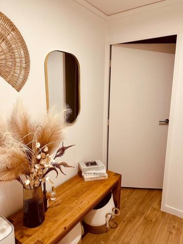 a room with a wooden table with a mirror at Le Cattleya in Dinard