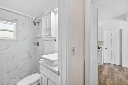 a white bathroom with a toilet and a sink at Buffalo Bungalow in Clearwater Beach