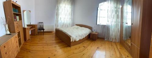 a bedroom with a bed and a wooden floor at Villa in and Home in Mardakan