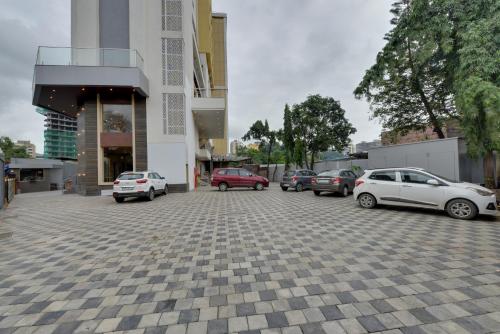 a parking lot with cars parked in front of a building at The Fern Residency Mira Road,Mumbai in Mumbai