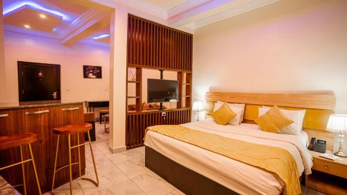 a hotel room with a bed and a flat screen tv at Apartment 79 Hotel & Suite in Ikeja