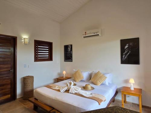 a bedroom with a white bed with towels on it at Azul Flats in Jericoacoara