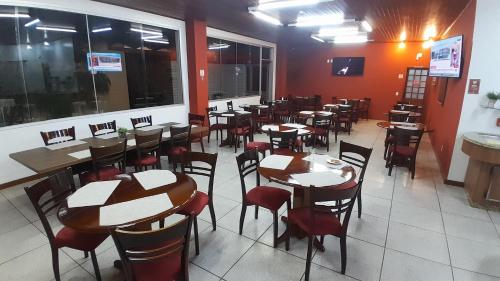 a restaurant with tables and chairs in a room at Goldmen Business Criciúma in Criciúma
