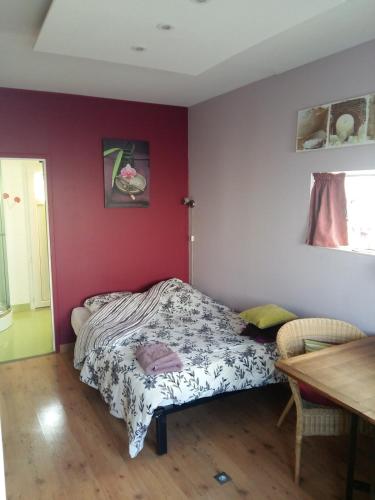 a bedroom with a bed and a red wall at Chambre cosy in Rezé