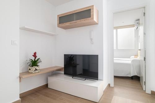a living room with a flat screen tv on a wall at Apartamentos Almadraba in Zahara de los Atunes